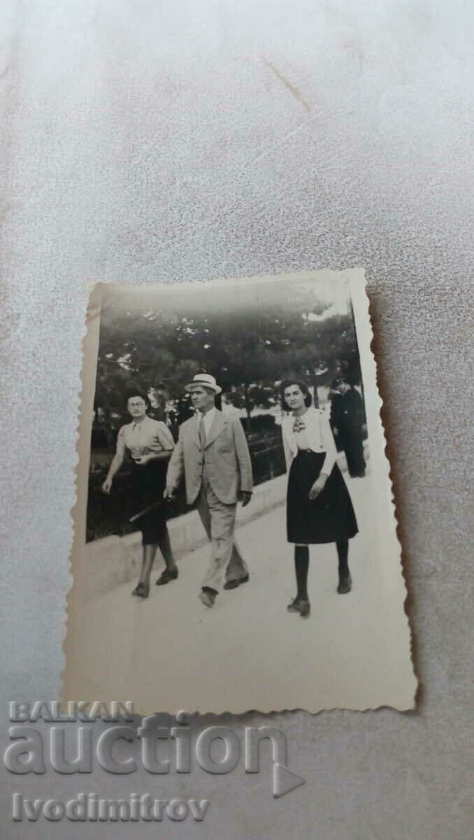 Φωτογραφία Ένας άνδρας και δύο νεαρές γυναίκες σε μια βόλτα