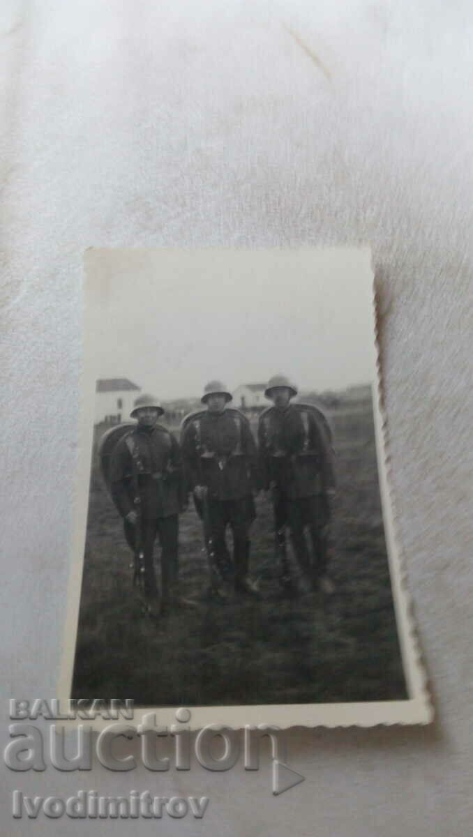 Foto Trei soldați cu puști și căști