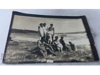 Снимка Младежи и девойки в ретро бански на камък в морето