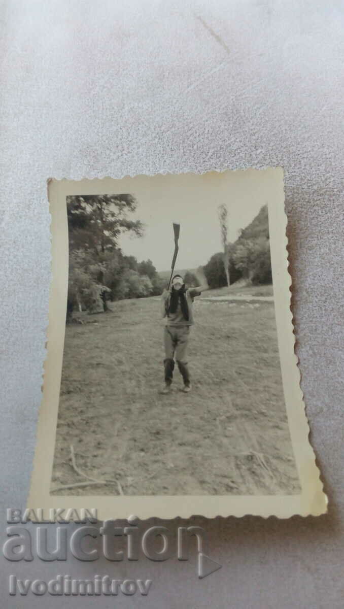 Fotografie O fată tânără jonglează cu o pușcă