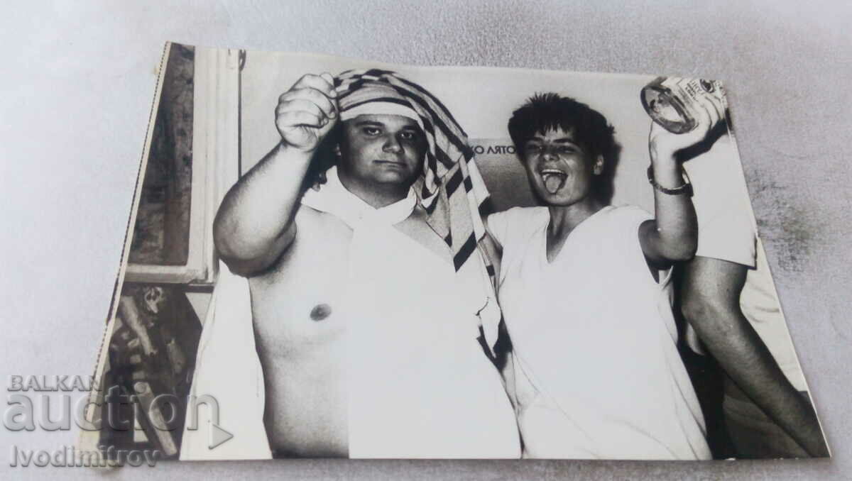 Foto Doi bărbați îmbrăcați în haine de femei la o petrecere