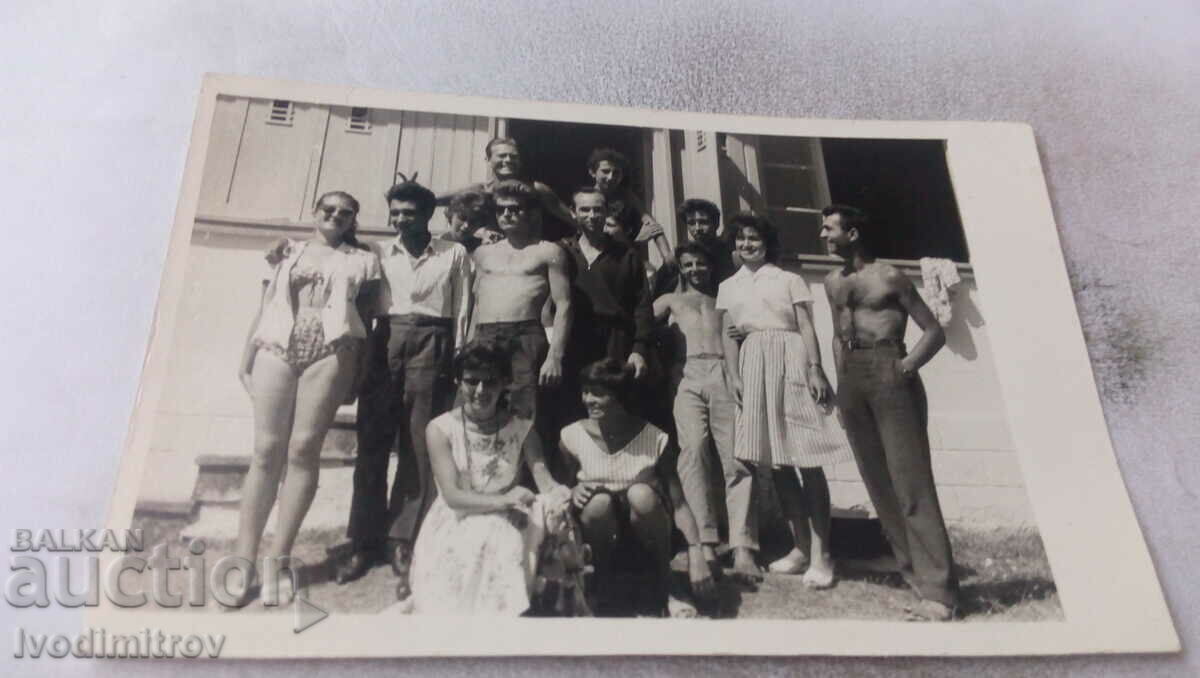 Photo Young men and young women in front of a large bungalow