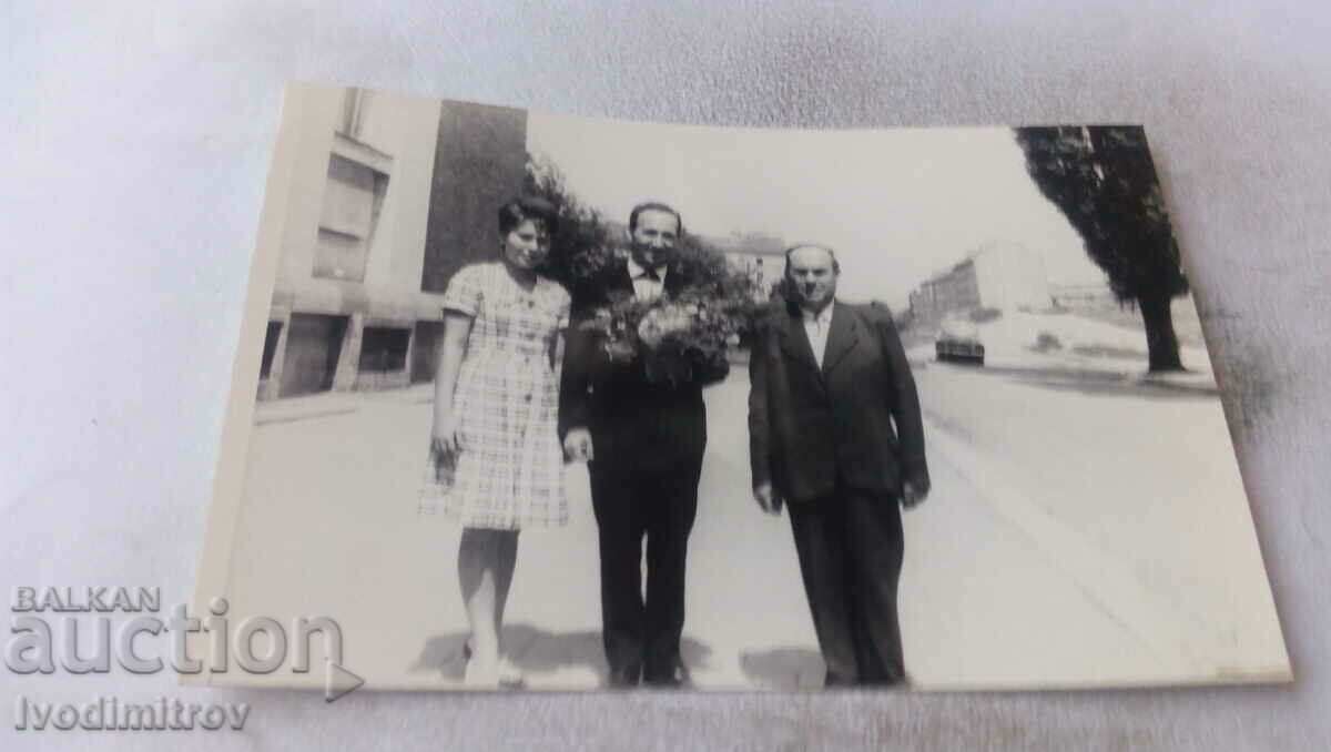 Foto Femeie și doi bărbați pe trotuar