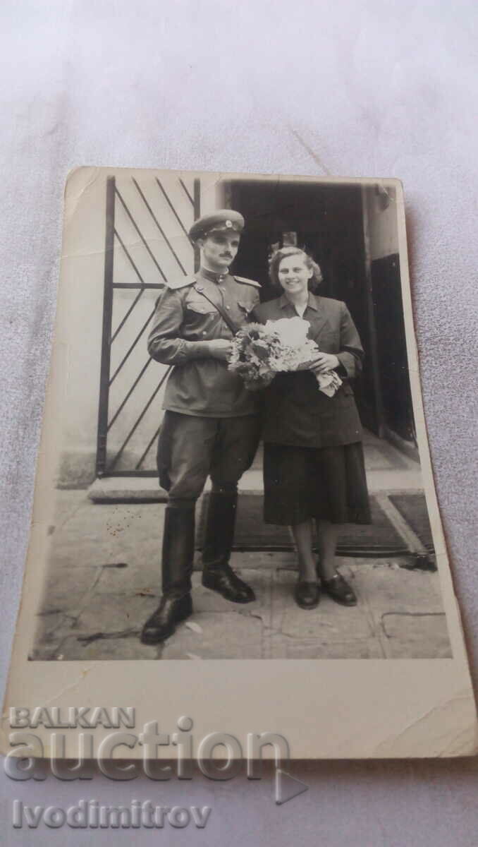 Ofițer foto și femeie cu un buchet de flori
