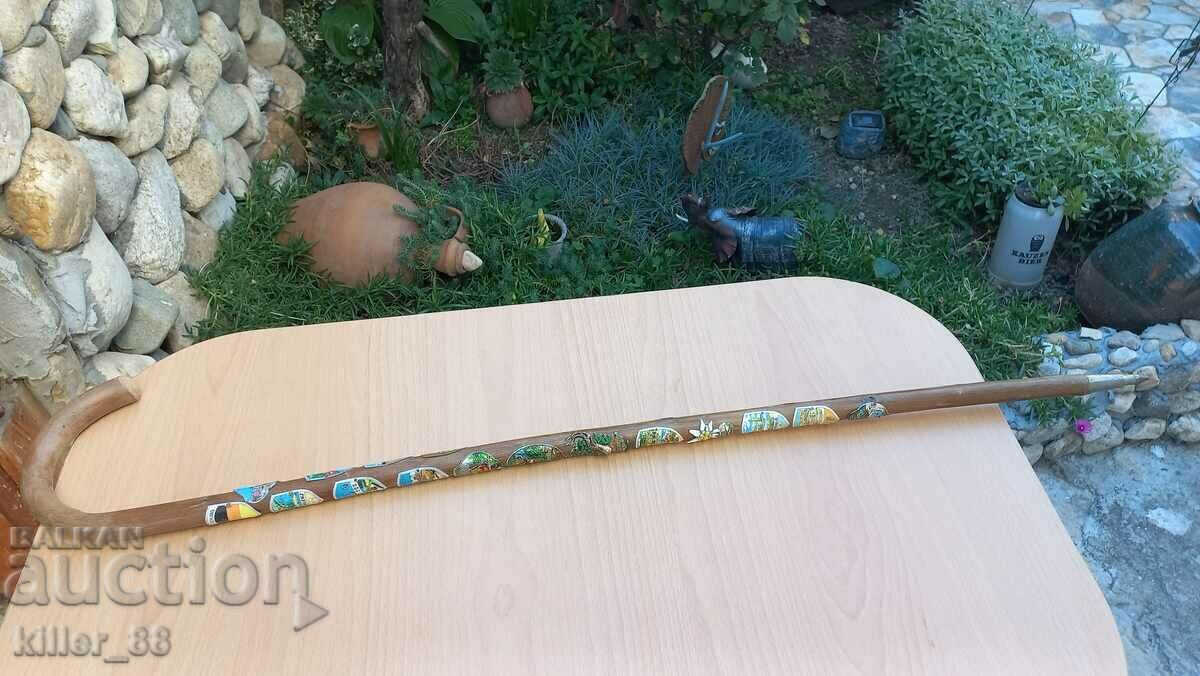 A hiking cane with many badges