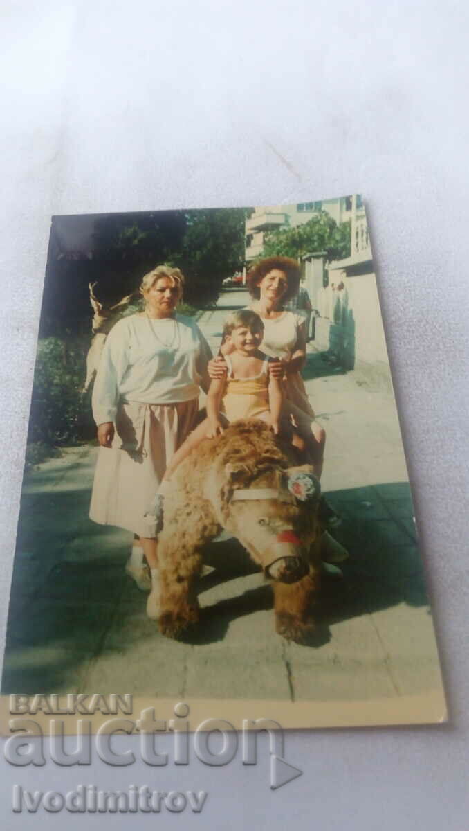 Fotografie Două femei și un băiat pe un urs