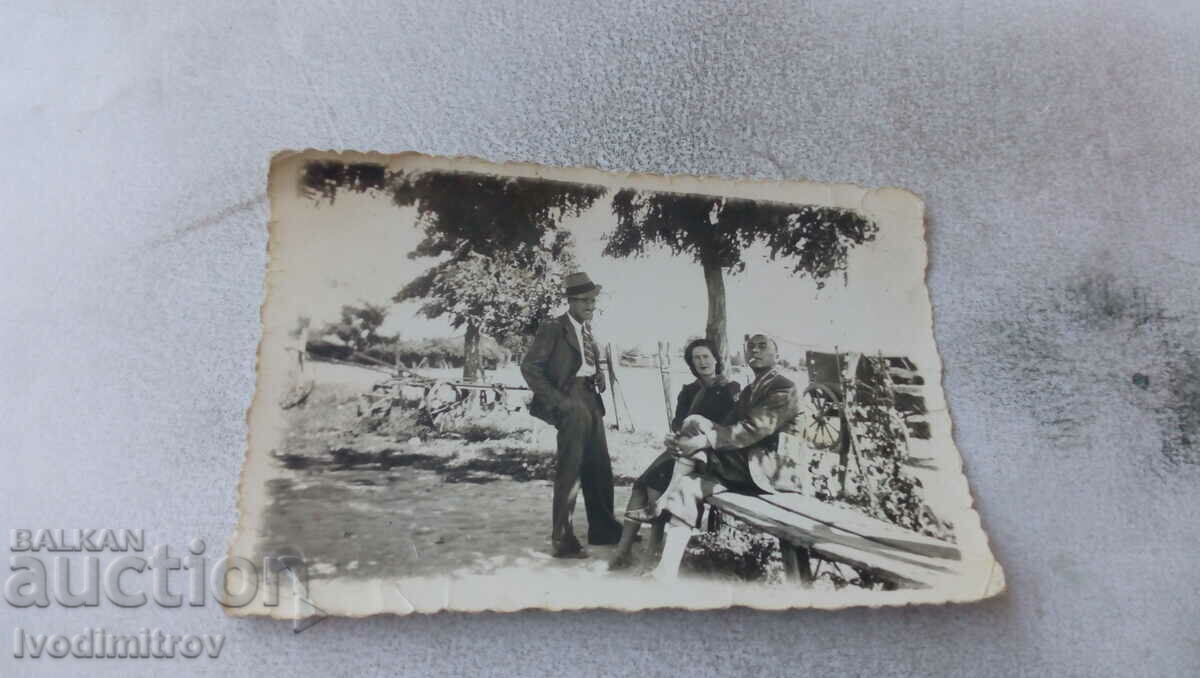 Photo Two men and a woman on a wooden bench