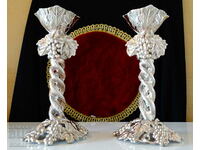 Silver-plated candlesticks, vines, grapes.