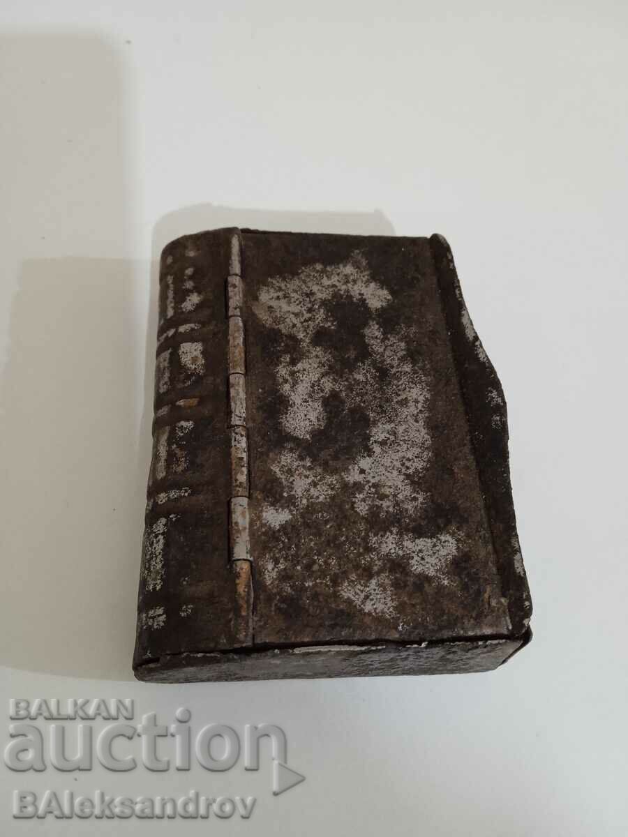 An old metal box in the shape of a book