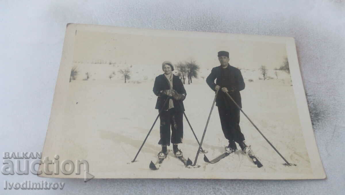 Photo Man and woman with retro skis
