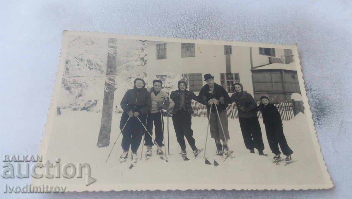 Photo Men women and girls with retro skis in the mountains