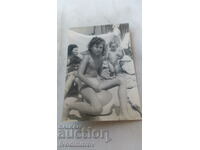 Foto Femeie și trei copii pe plajă