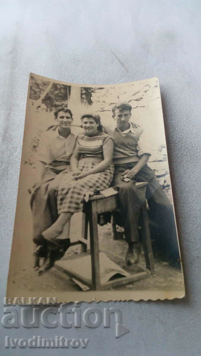 Снимка Двама мъже и жена седнали върху маса