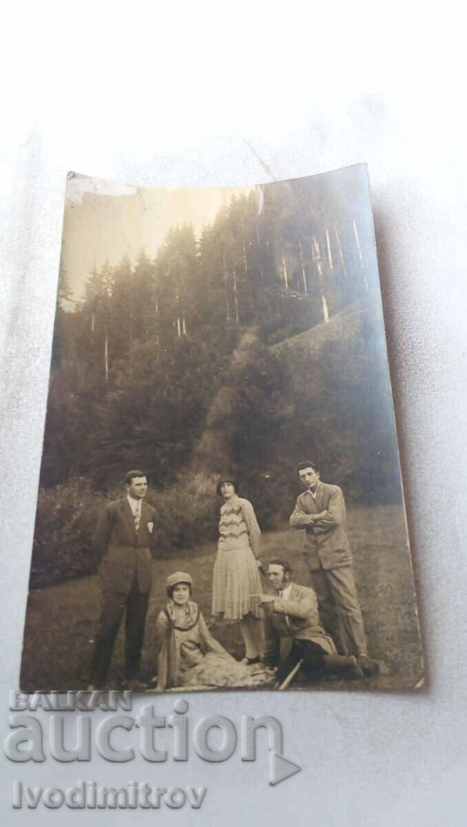 Photo Three men and two women on a meadow in the forest
