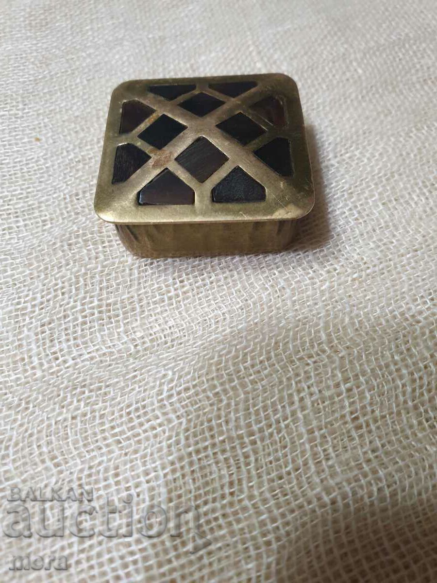 O cutie mică de alamă cu plăci de corn aplicate