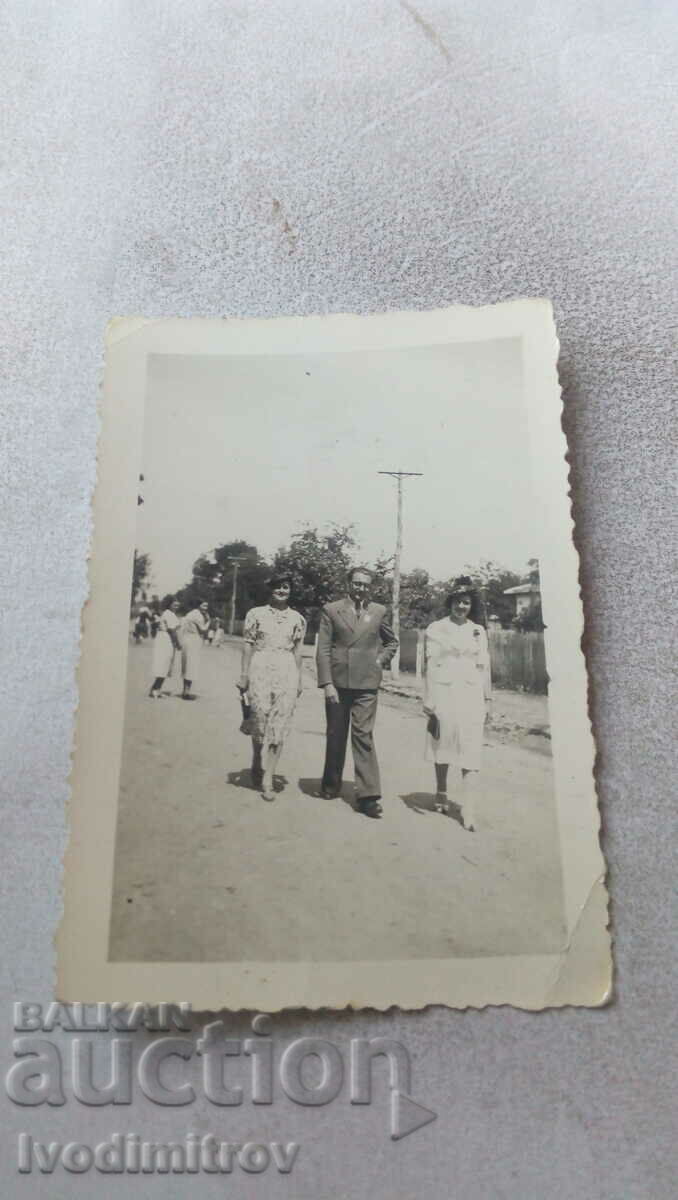 Fotografia unui bărbat și a două femei la plimbare