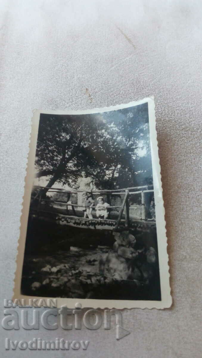 Снимка Жена с две малки деца на дървен мост над река 1953