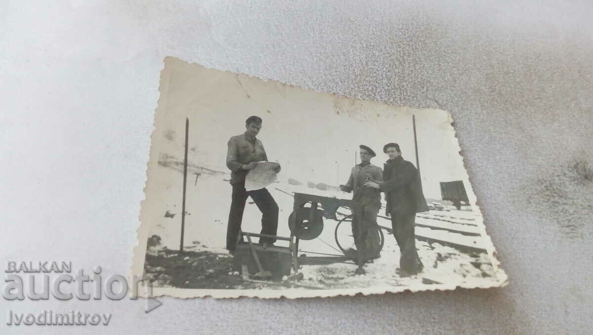 Снимка Трима мъже покрай железопътни релси през зимата