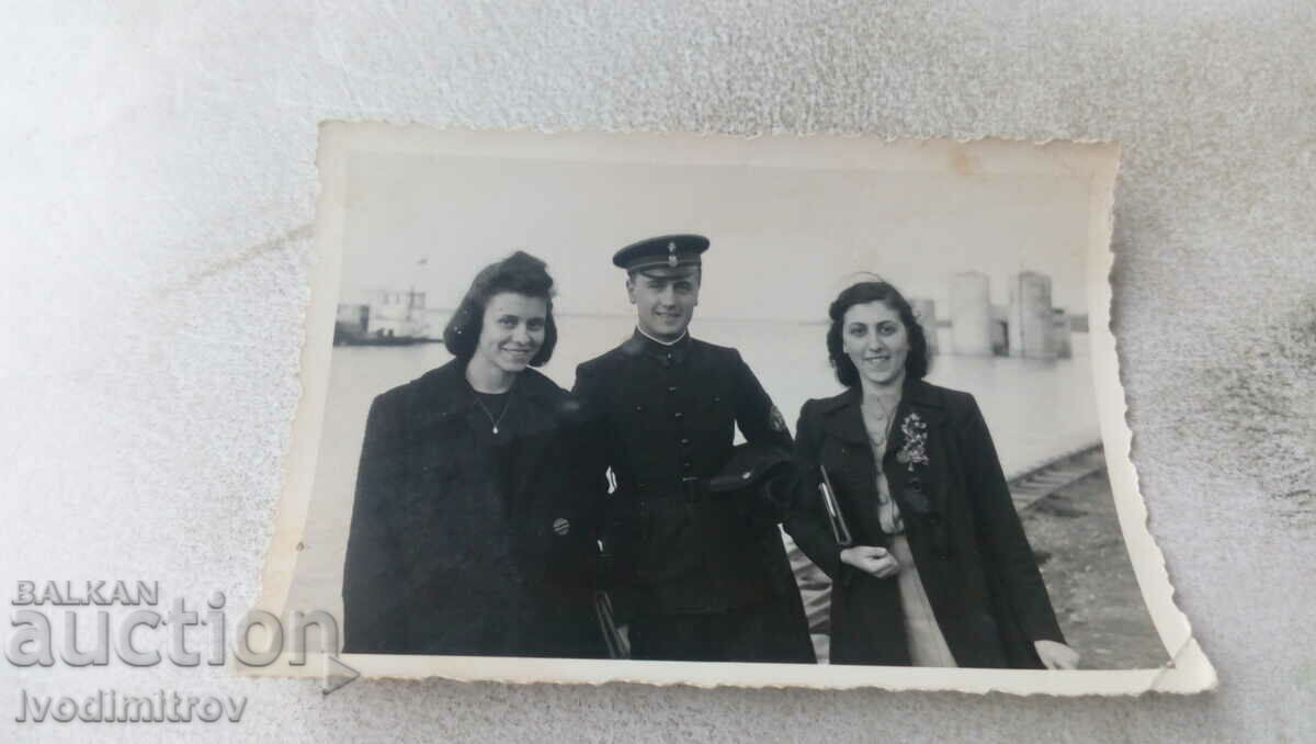 Foto Un ofițer și două tinere în port