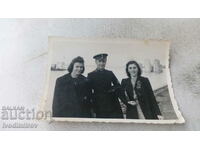 Φωτογραφία Ένας αξιωματικός και δύο νεαρές γυναίκες στο λιμάνι