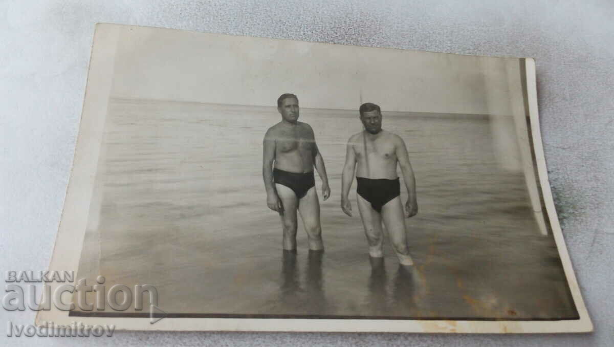 Photo Two men in swimsuits on the beach