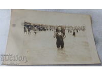Foto Femeie în costum de baie retro cu umbrelă de burtă în mare