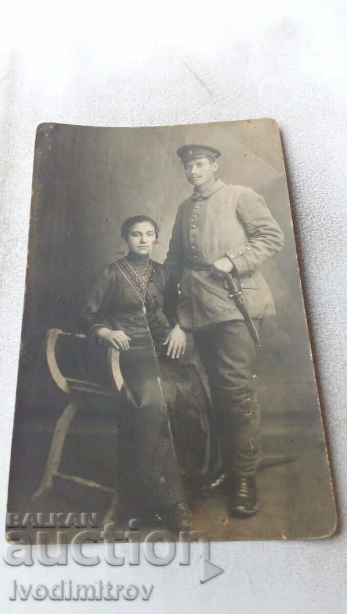 Φωτογραφία Ένας στρατιώτης με ένα μαχαίρι και μια νεαρή γυναίκα