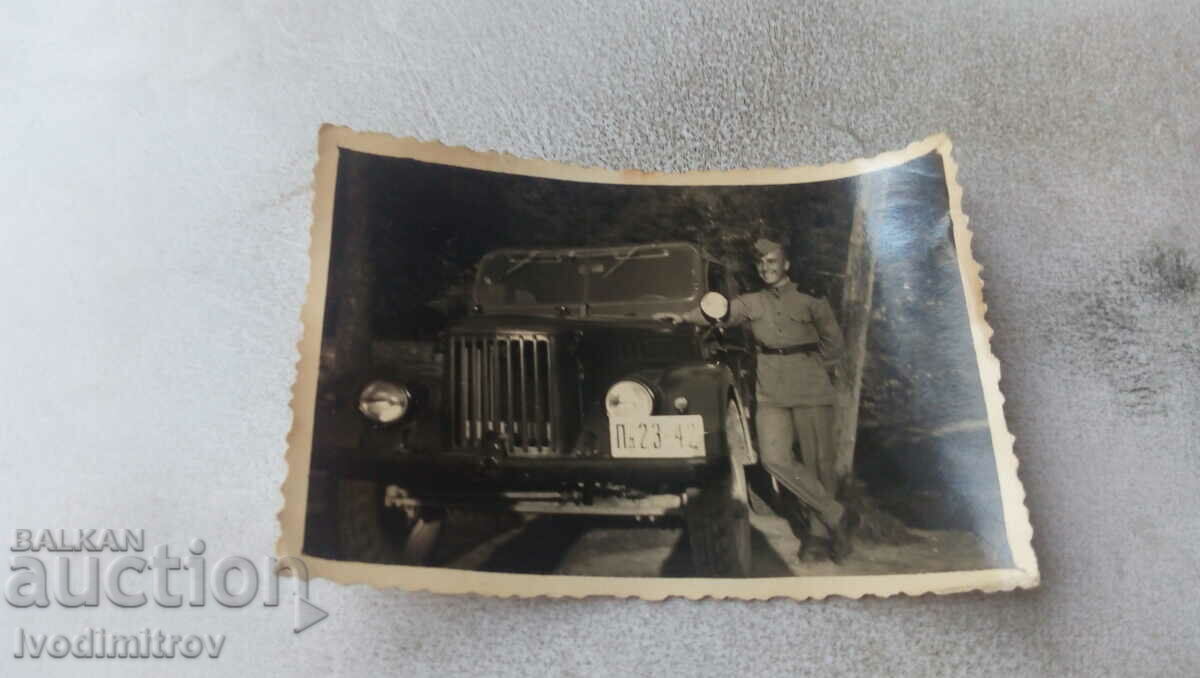Φωτογραφία Στρατιώτης δίπλα σε ένα vintage στρατιωτικό φορτηγό