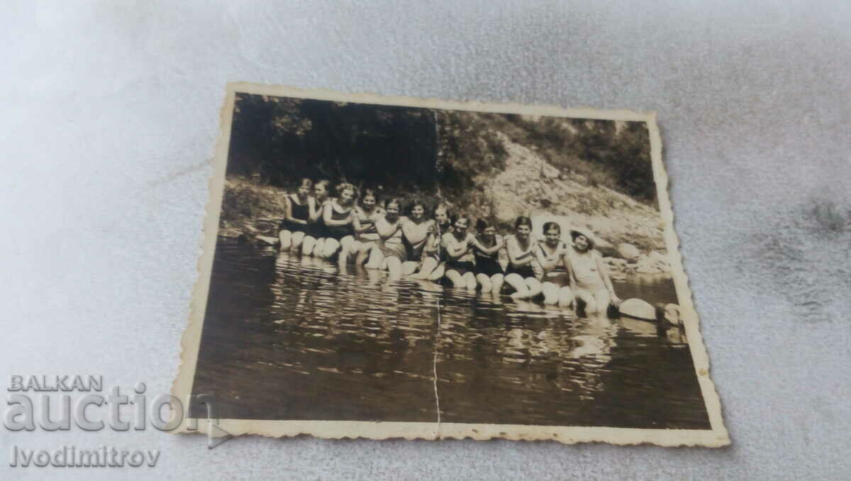 Photo Young girls in vintage swimsuits sitting on a river embankment