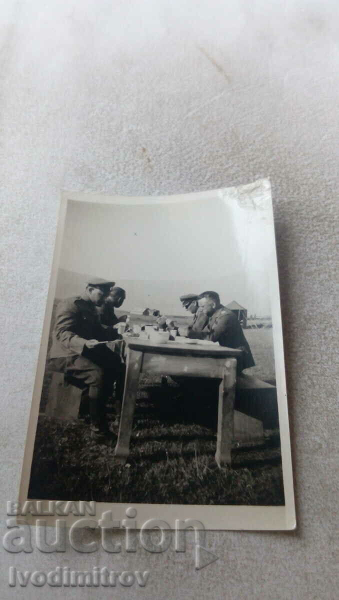 Αξιωματικοί φωτογραφιών γευματίζουν σε ένα ξύλινο τραπέζι