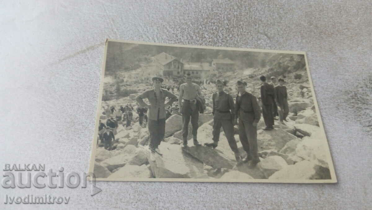 Photo Soldiers on stones in front of a mountain hut