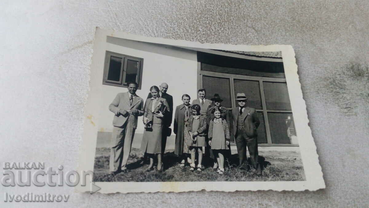 Foto Bărbați, femei și două fete în fața unei case, 1938