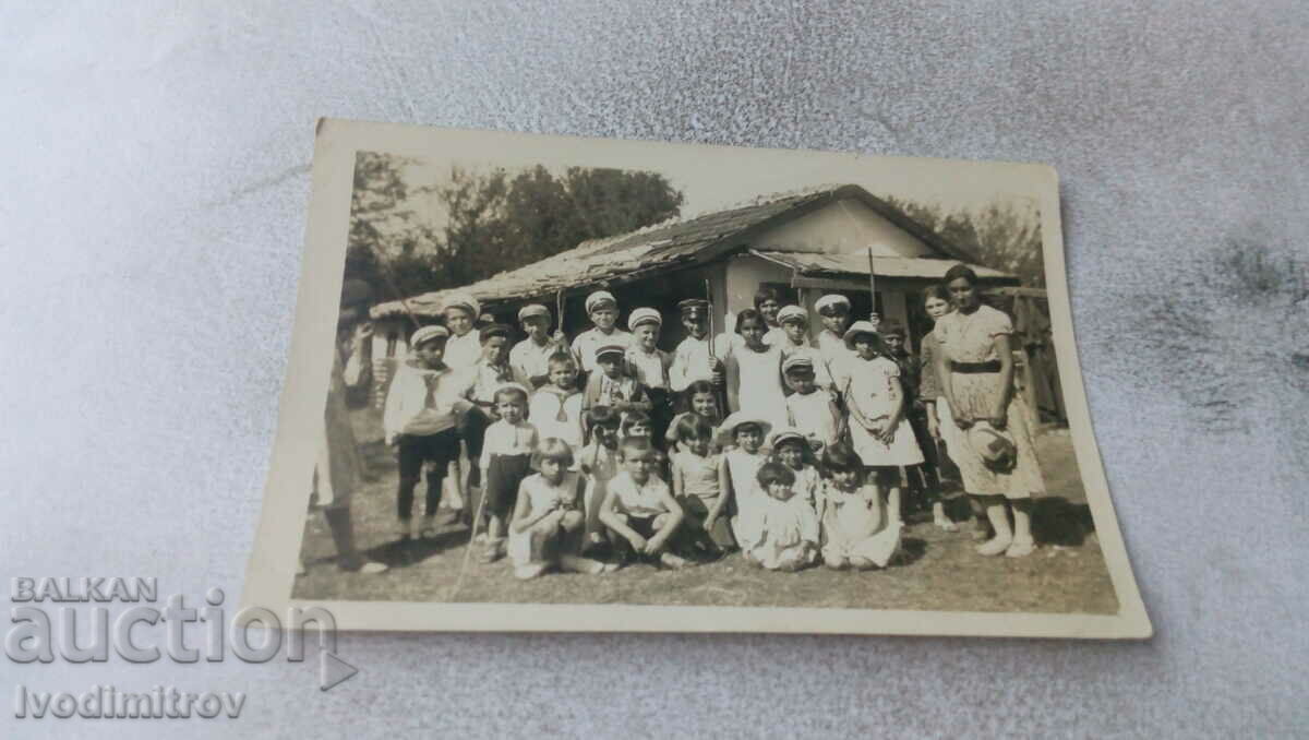 Photo Children with their teacher in front of an old house