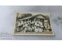 Foto Copii cu profesorul lor în fața unei case vechi