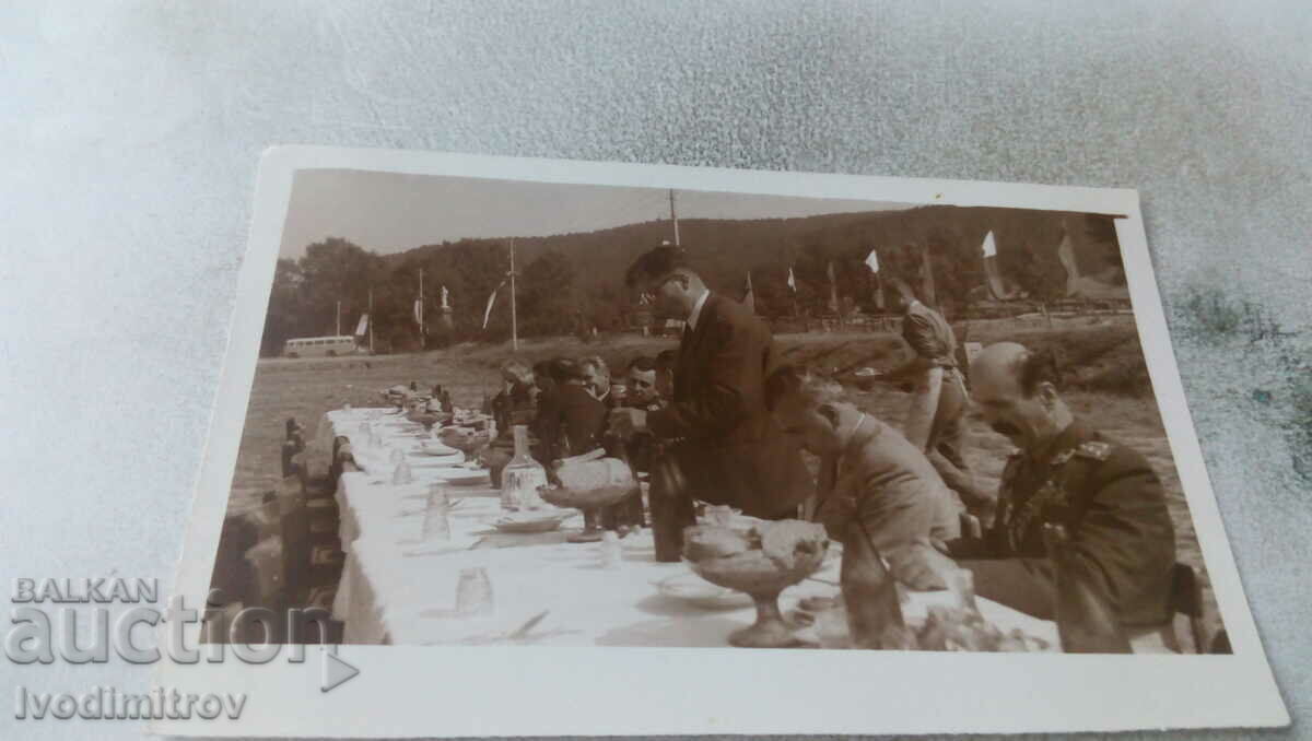 Αξιωματικοί φωτογραφιών και άνδρες σε ένα μακρύ τραπέζι