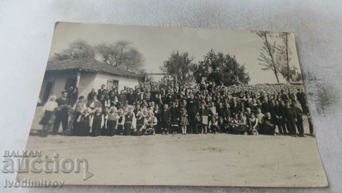 Picture Men, women and children in a large yard of an old house