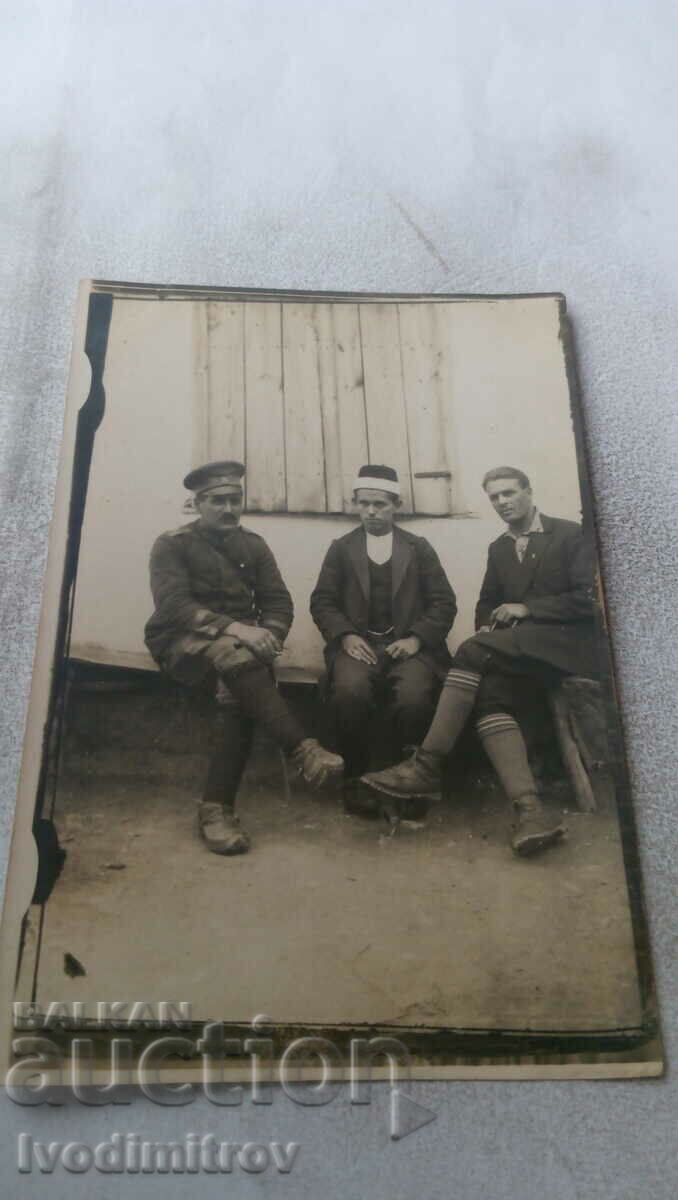 Fotografie Un ofițer și doi bărbați pe o bancă de lemn