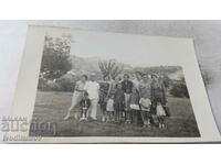 Fotografie Plachkovtsi Doi bărbați, femei și copii pe pajiște 1932