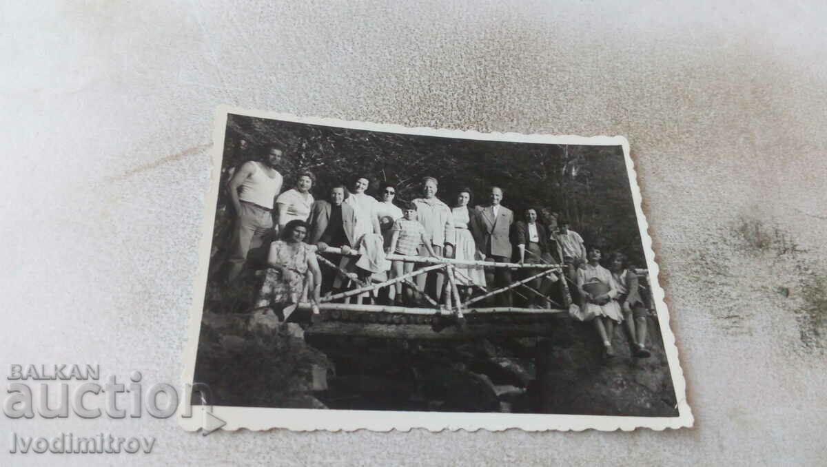 Φωτογραφία Άνδρες, γυναίκες και παιδιά σε μια ξύλινη γέφυρα