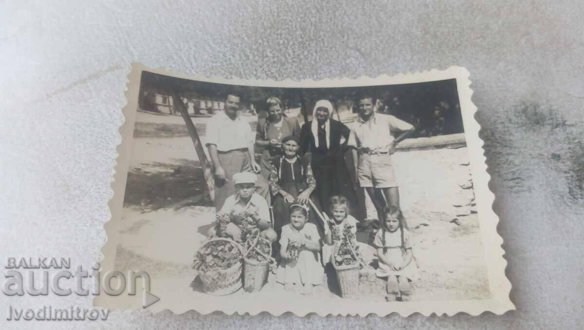 Снимка Мъже жени и деца с плетени кошници с чепки грозде