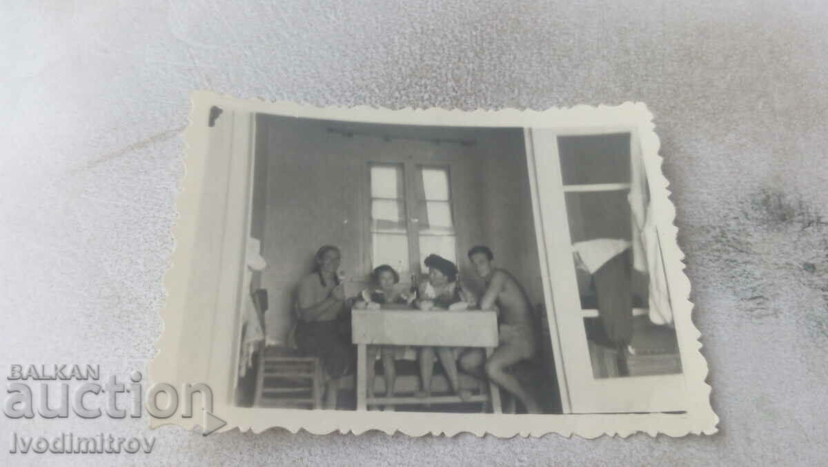 Φωτογραφία Άνδρας δύο γυναίκες και ένα κορίτσι σε ένα δωμάτιο σε ένα τραπέζι