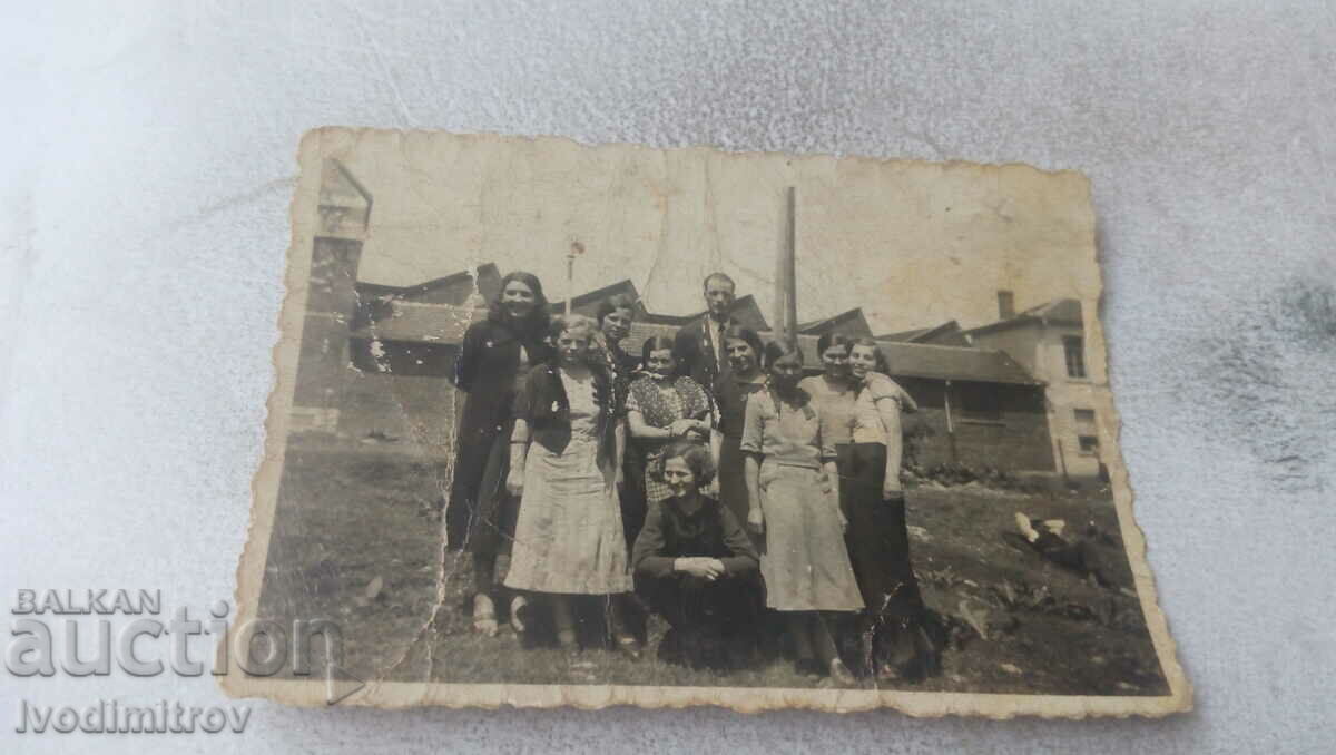 Photo Man and young women in front of a factory