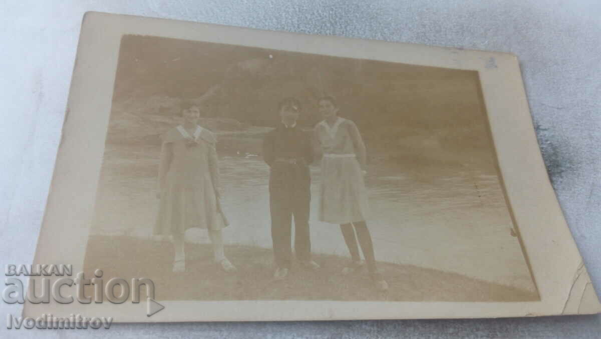 Φωτογραφία Ένας νεαρός άνδρας και δύο νεαρά κορίτσια δίπλα στο ποτάμι