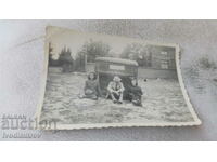 Φωτογραφία Ένας άνδρας και δύο γυναίκες κάθονται μπροστά από μια καμπίνα φορτηγού