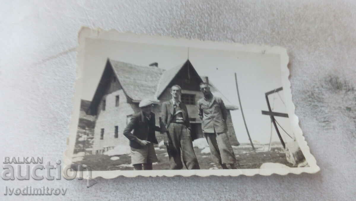Photo Two men and a boy in front of a newly built house