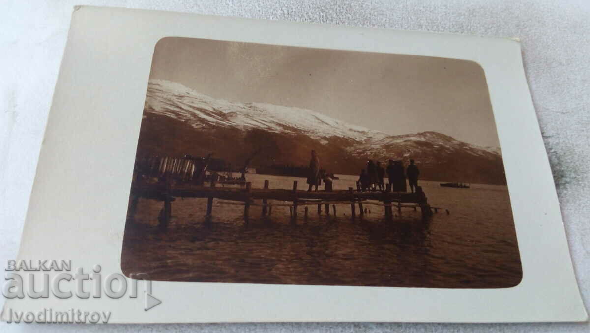 Picture Men and women on a pier on a lake