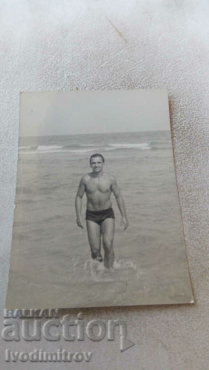 Φωτογραφία Άνδρας με μαγιό δίπλα στη θάλασσα