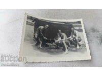 Foto Trei bărbați în pantaloni scurți în fața unui rezervor de apă