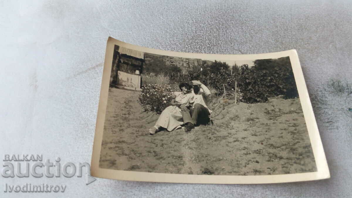 Photo A man and a young woman on a meadow in front of a well