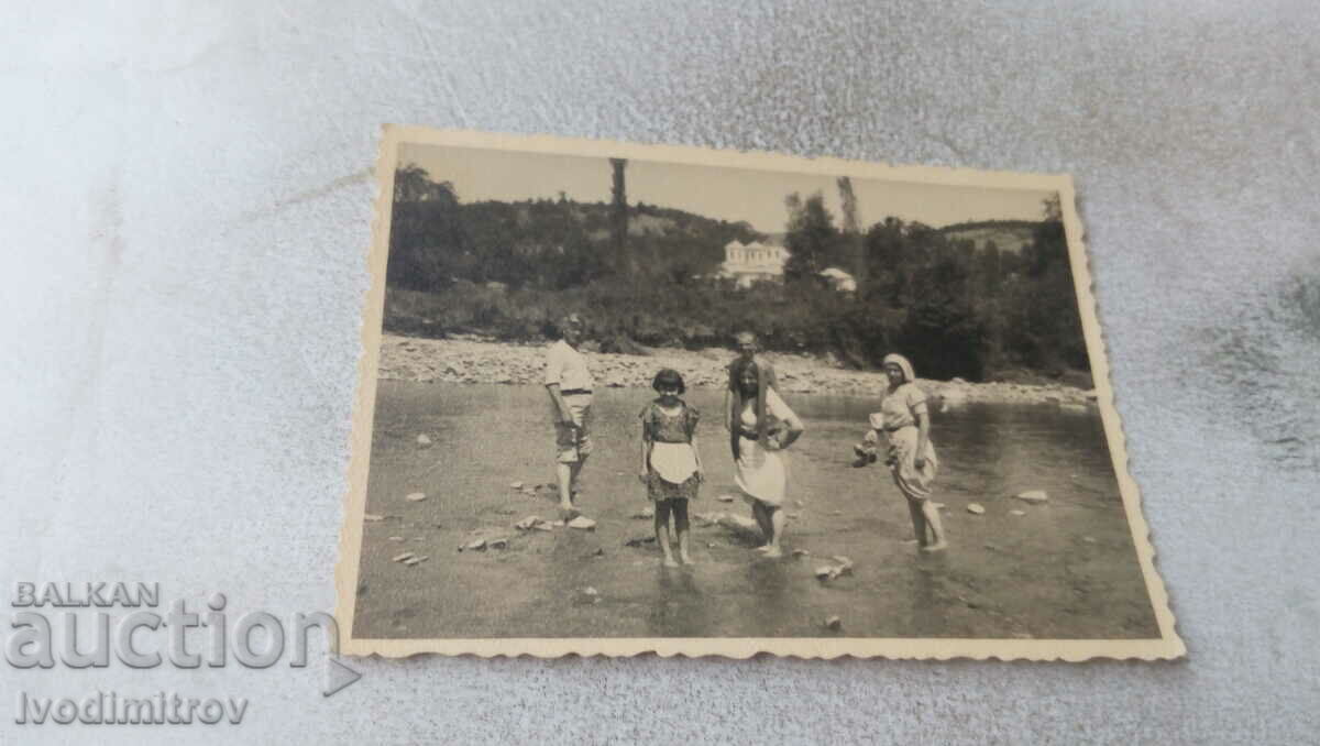 Imagine Doi bărbați, două femei și o fată în râu